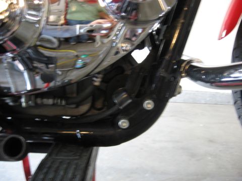 2004 Harley-Davidson Sportster Custom - Detail shot of a motorcycle's engine and frame components, showing various pipes and bolts.