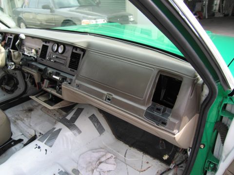 1991 Ford LTD Crown Victoria - passenger side of a sedan's tan dashboard with open glovebox area and the floor stripped to bare metal.