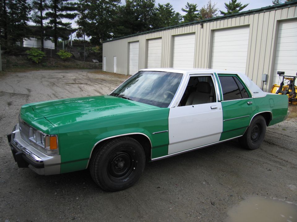 Green and white two-tone sedan front three-quarter view outdoors