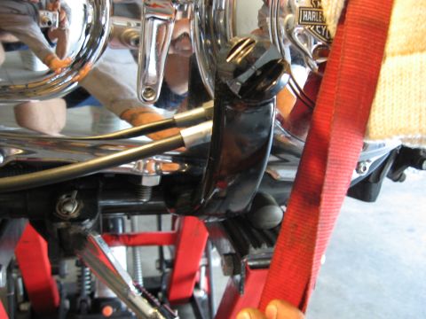 2004 Harley-Davidson Sportster Custom - A red strap is secured around the engine and frame of a motorcycle, which is on a red lift.
