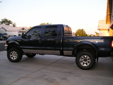 2001 Ford F-350 - Side view of a lifted 2001 Ford F-350 pickup truck with a crew cab and long bed.