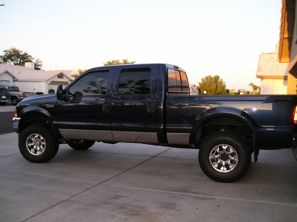 Dark blue 2001 Ford F-350 pickup truck with chrome wheels parked on a driveway