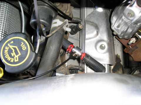 2001 Ford F-350 - Close-up view of engine bay components, including hoses and an oil cap, with visible oil stains.