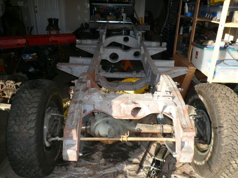1974 Land Rover Land Rover - The frame and tires of a vehicle are shown in a workshop setting.