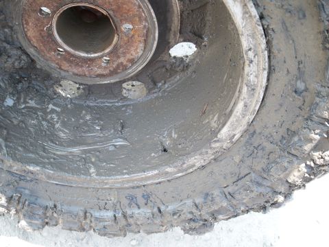 1996 Ford Bronco - A close-up view of a heavily mud-covered wheel and tire, obscuring any identifying details.