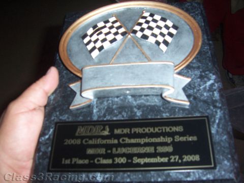 1990 Ford Bronco - hand holds a marble trophy plaque with crossed checkered flags reading MDR Productions 2008 California Championship, 1st Place Class 300.