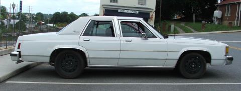 1985 Ford Crown Victoria LTD - This 1985 Ford Crown Victoria LTD is seen from the side, parked in a lot.