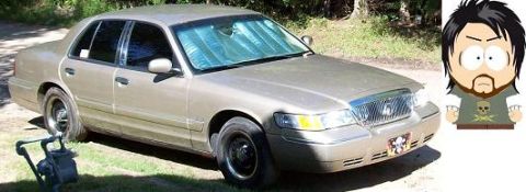2000 Mercury Grand Marquis - A gold 2000 Mercury Grand Marquis is parked outdoors, viewed from the front three-quarter angle.