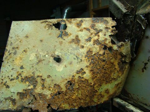 1948 Jeep Wrangler - This heavily rusted metal panel shows significant deterioration and peeling paint.