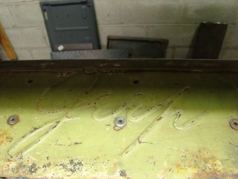 1948 Jeep Wrangler - Embossed lettering is visible on a painted metal surface, with some rust and wear apparent.
