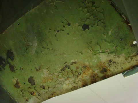 1948 Jeep Wrangler - Peeling green paint and rust on a metal surface, possibly from an old vehicle part.