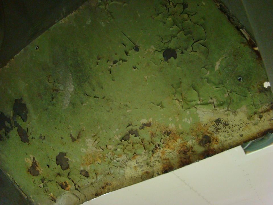 Close-up of peeling green paint and rust on a metal surface