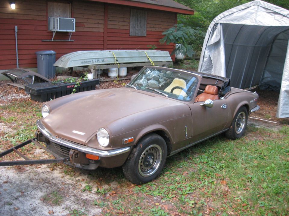 Brown convertible sports car with tan interior, parked outdoors