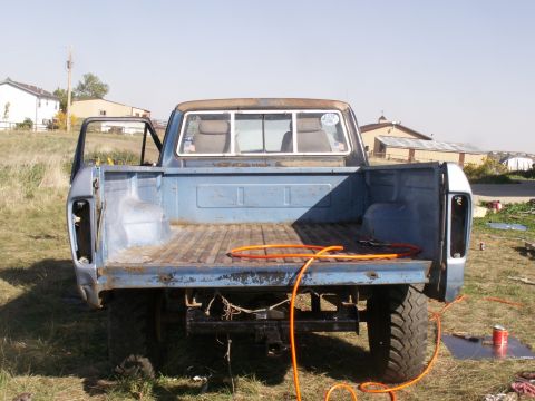 1977 Ford F-250 - Rear view of a blue 1977 Ford F-250 pickup truck with the driver's door ajar.
