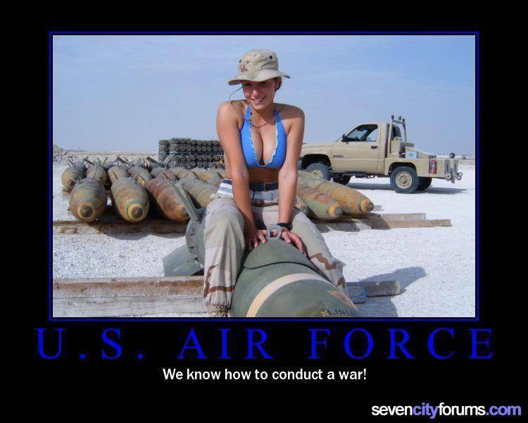 Woman in bikini top and hat sits on a bomb in front of a truck and more bombs