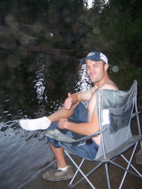 1991 Ford Bronco - Man relaxing in a camping chair by the water, giving a thumbs up.