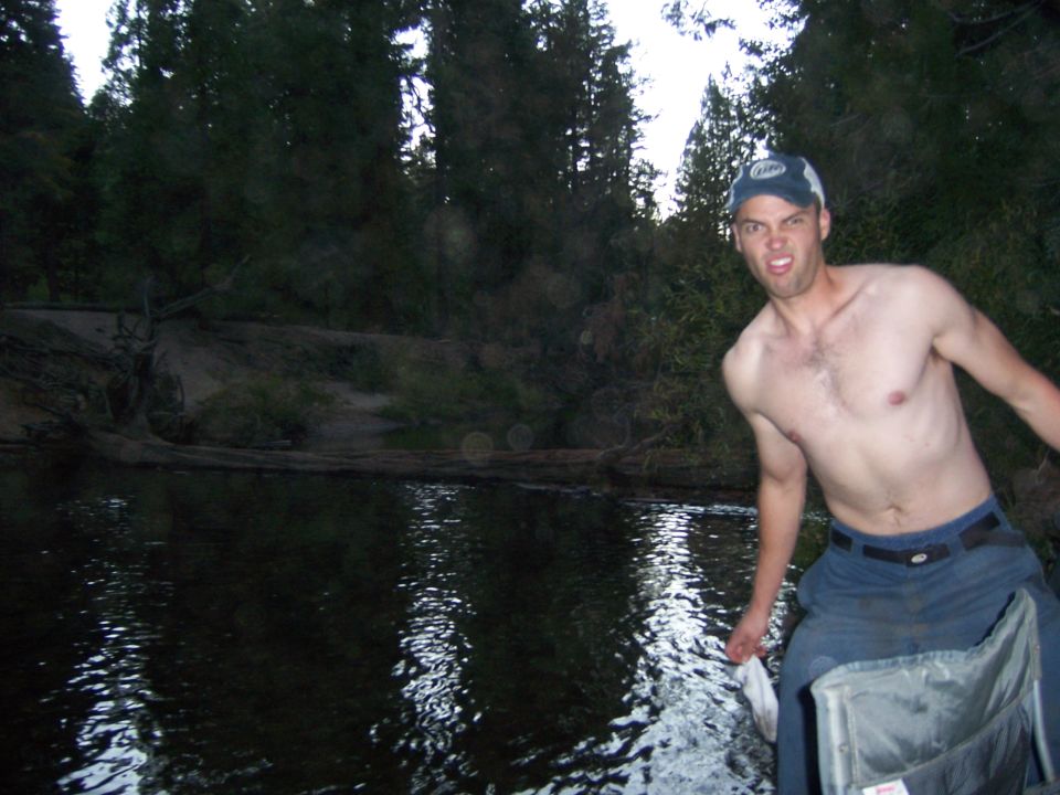 Man in a boat with trees and water in the background