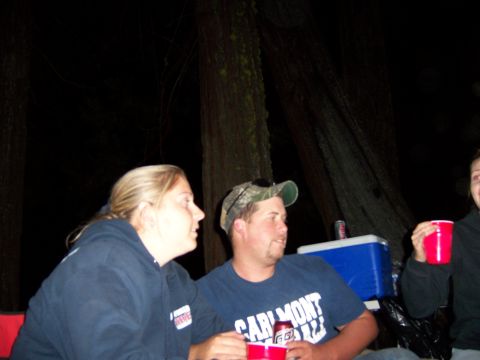 1991 Ford Bronco - People gather around a table at a campsite with a cooler and drinks.
