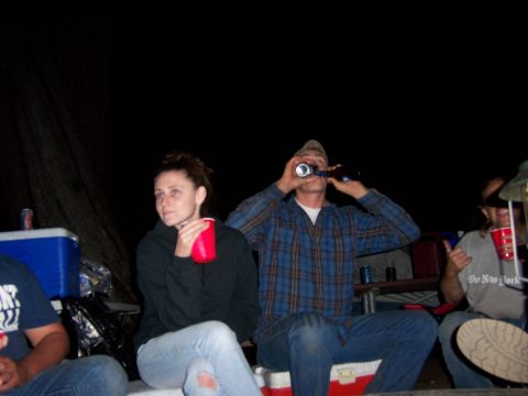 1991 Ford Bronco - Several people are gathered around at night, some holding red cups and drinking from bottles.