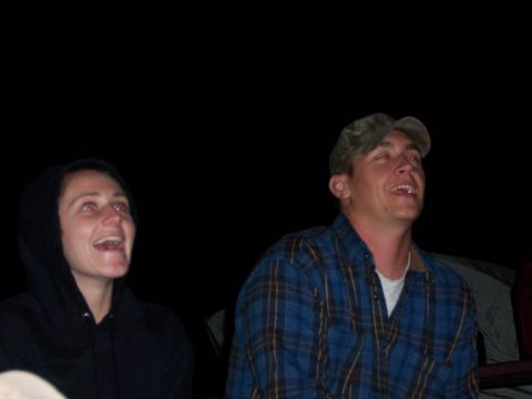 1991 Ford Bronco - Two people are captured in a moment of amusement, looking upwards against a dark background.