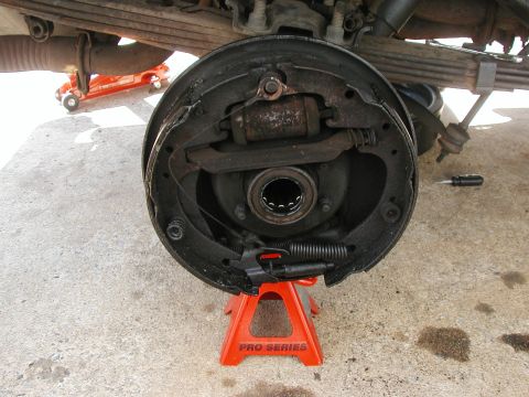 1989 Ford Bronco - Picture of the passenger side with the old brakes and the axle out. The ring in the middle is the bad oil seal. Behind that you see a bit o…