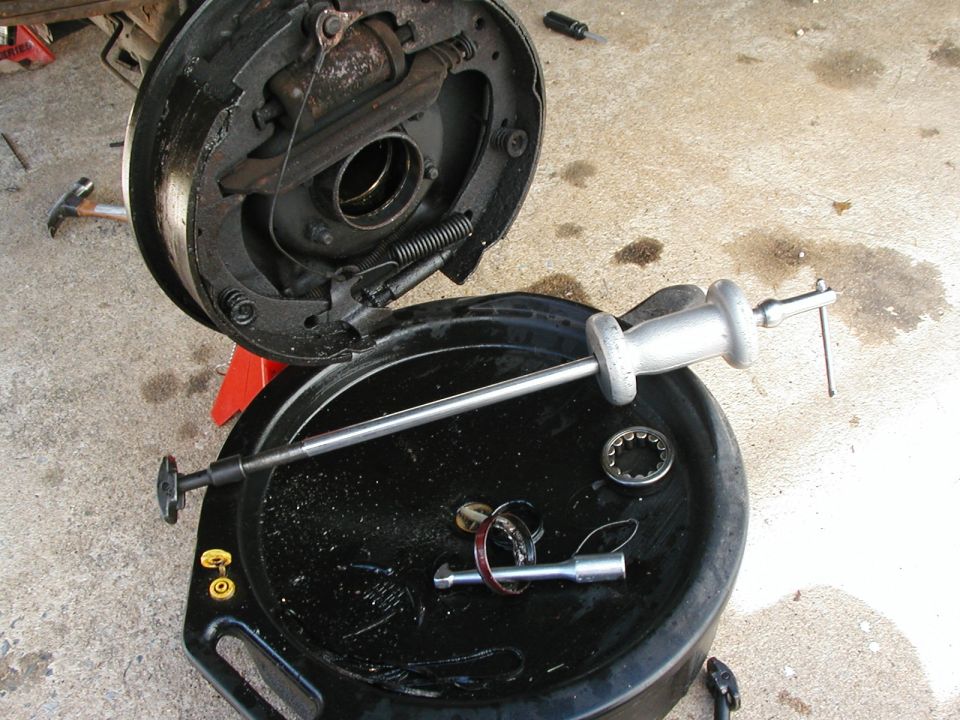 Slide hammer at work.  I rented this one from Adavance Auto in my town.  Great store.  Only go there.  I had to pay the full price of the tool, but you get it all back.  If you only want to pull out the oil seal, use the hook (on pan, going through the old seal).  If you' re going to replace both the seal and bearing, use the end that looks like a rocker on your engine.  Pulls both right out.  Pull off the brakes and clean the backing plate well with brake cleaner