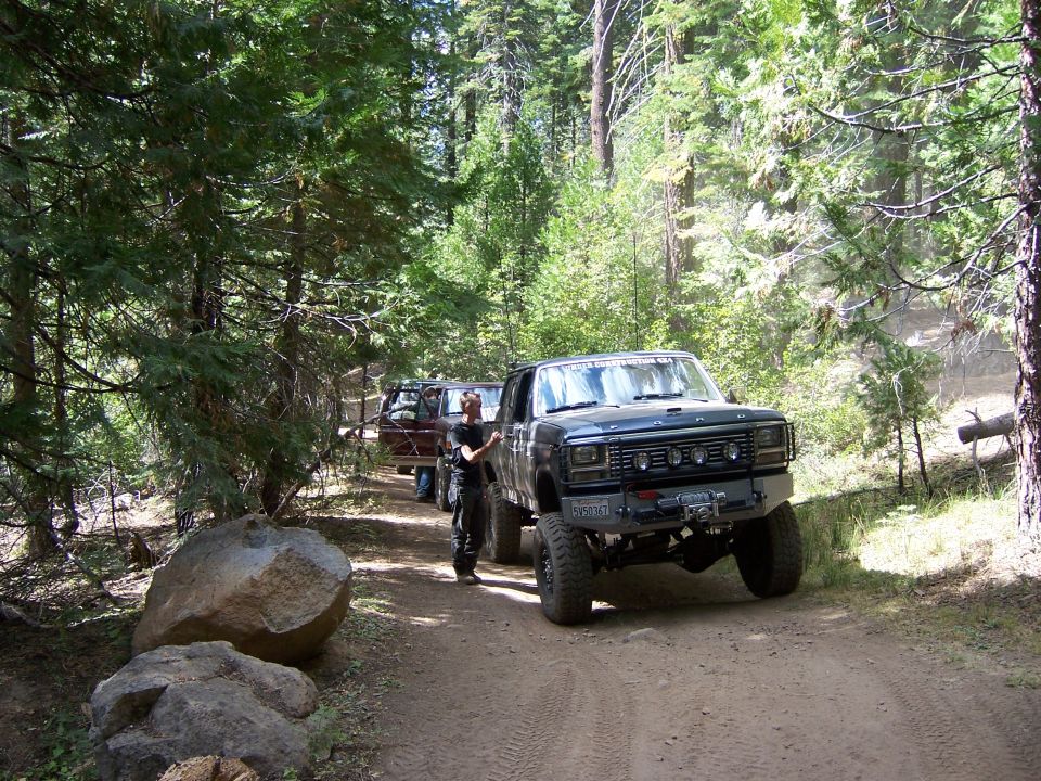 Ford F-series truck on dirt road with another vehicle behind it