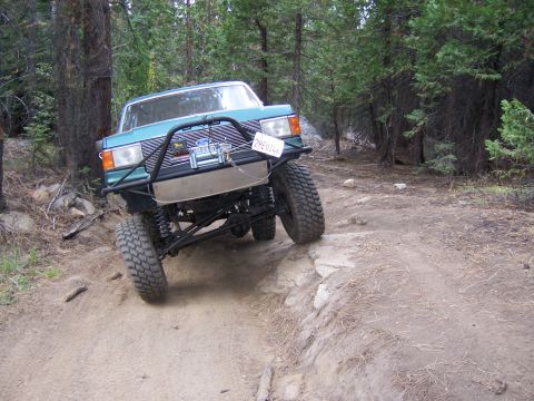 1991 Ford Bronco - This modified Ford Bronco navigates a challenging off-road path through a wooded area.