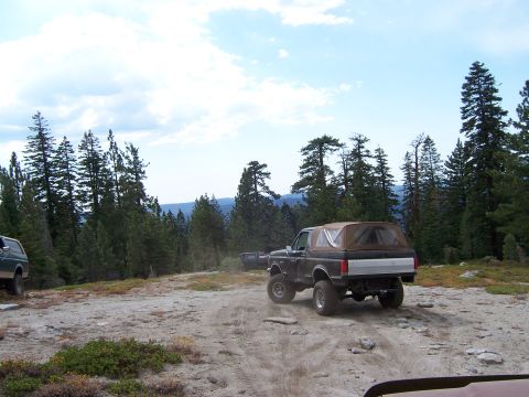 1991 Ford Bronco - A 1991 Ford Bronco navigates a dusty trail through a wooded mountain landscape.