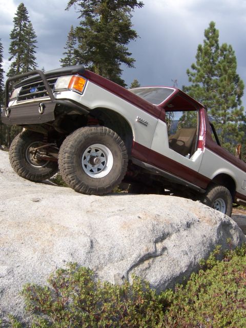1991 Ford Bronco - This modified Ford Bronco navigates a rocky trail in a wooded area.