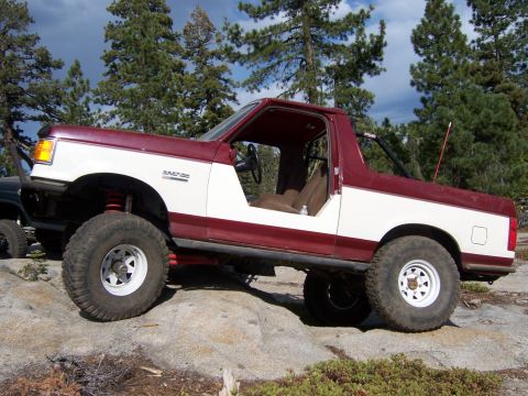 1991 Ford Bronco - A modified Ford Bronco navigates rocky terrain, its off-road capabilities.