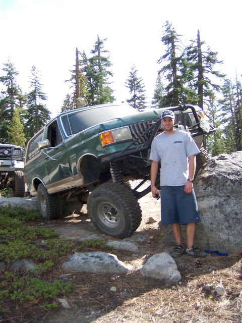 1991 Ford Bronco - A modified 1991 Ford Bronco navigates a rocky trail with a person standing nearby.