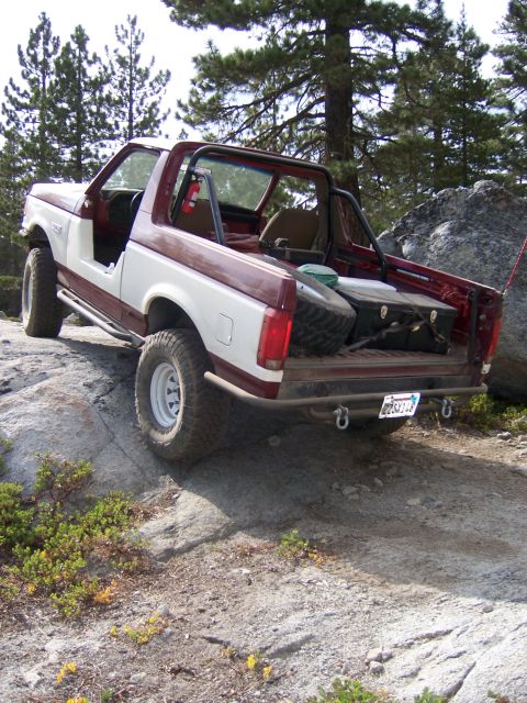 1991 Ford Bronco - This 1991 Ford Bronco is shown navigating a rocky trail, highlighting its off-road capabilities.