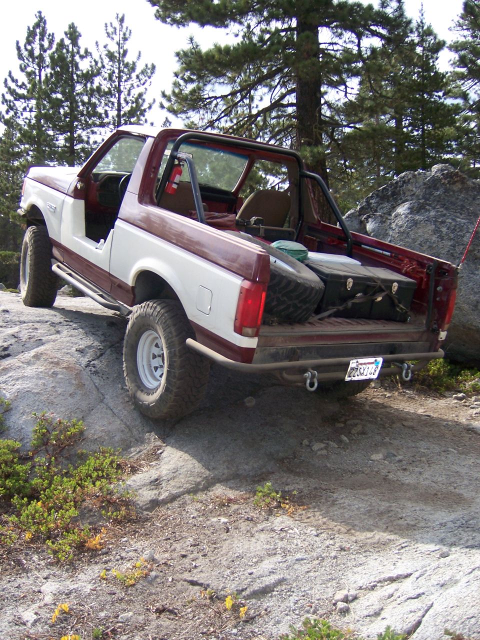 1991 Ford Bronco 3q-front view, two-tone red and white, off-roading on rocks
