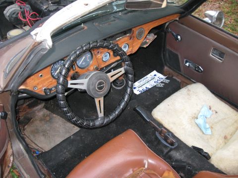 1991 Ford Bronco - The interior of a car shows a wood-grain dashboard and a Virginia license plate lying on the floor.