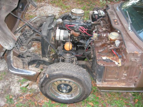 1991 Ford Bronco - Front end of a Triumph Spitfire with the hood open, revealing the engine and surrounding components.