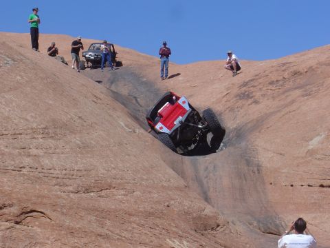 1986 Ford Bronco II - Spectators watch an off-road vehicle navigate a challenging rocky terrain in Moab.