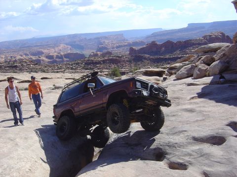 1986 Ford Bronco II - A 1986 Ford Bronco II navigates a rocky trail in a desert landscape.