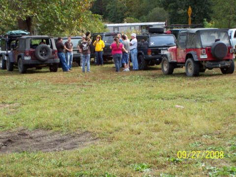 1992 Jeep Cherokee - Multiple Jeep Cherokees and Wranglers gathered in a grassy area with people milling about.