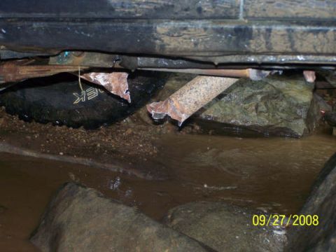 1992 Jeep Cherokee - The vehicle appears to be stuck on rocks in a watery area, with visible undercarriage damage.