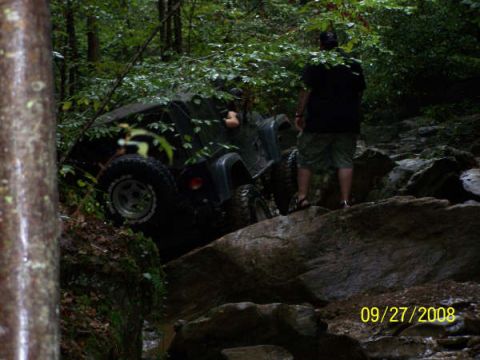 1992 Jeep Cherokee - A Jeep Wrangler navigates a challenging off-road trail through a wooded area.