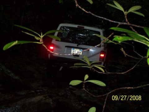 1992 Jeep Cherokee - A white Jeep Cherokee navigates a dark, wooded trail at night.