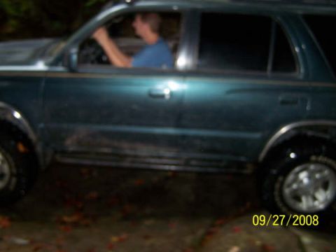 1992 Jeep Cherokee - A dark green SUV is seen from the side, with a driver behind the wheel. The image is dated 09/27/2008.