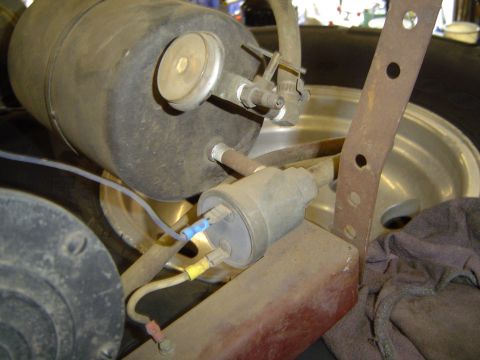 1978 Ford Bronco - This image shows a close-up view of automotive components, including a vacuum canister and associated wiring and hoses.