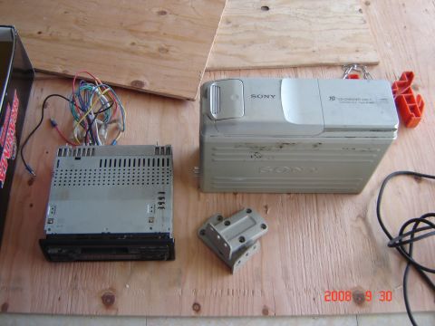 1993 Ford Bronco - Car stereo head unit and Sony 10-disc CD changer are laid out on a wooden surface with various wires and a mounting bracket.