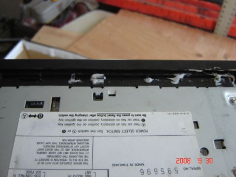 1993 Ford Bronco - Close-up of the rear of a car stereo unit, showing connection ports and warning labels.