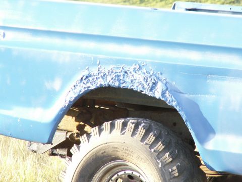 1977 Ford F-250 - Rust has severely damaged the rear wheel well of this blue truck, obscuring any specific year identification.