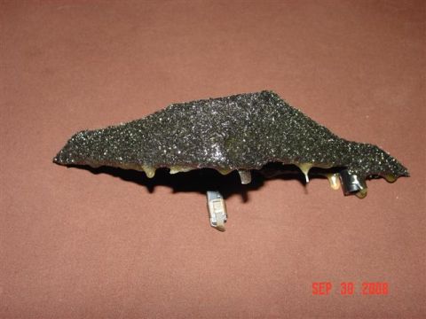 1993 Ford Probe - A close-up view of an automotive part covered in black texture and dripping with yellow adhesive.