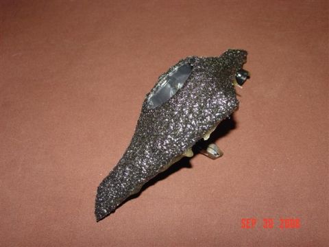 1993 Ford Probe - Close-up of an automotive part with a textured black coating and visible metal components.