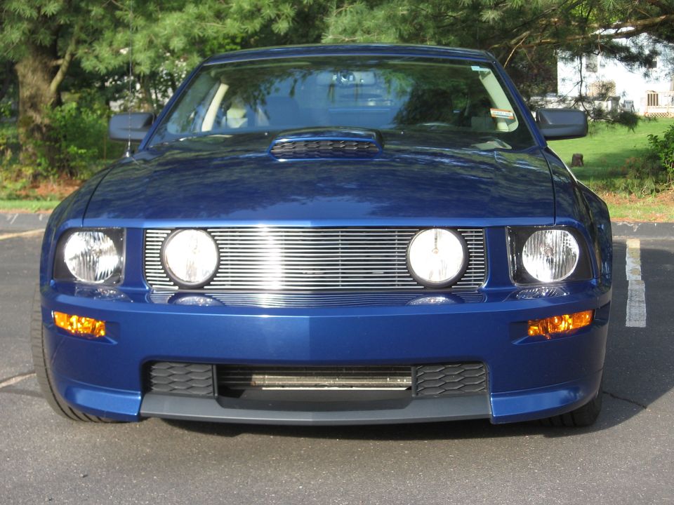 Front view of a blue 2007 Ford Mustang with a chrome grille and hood scoop